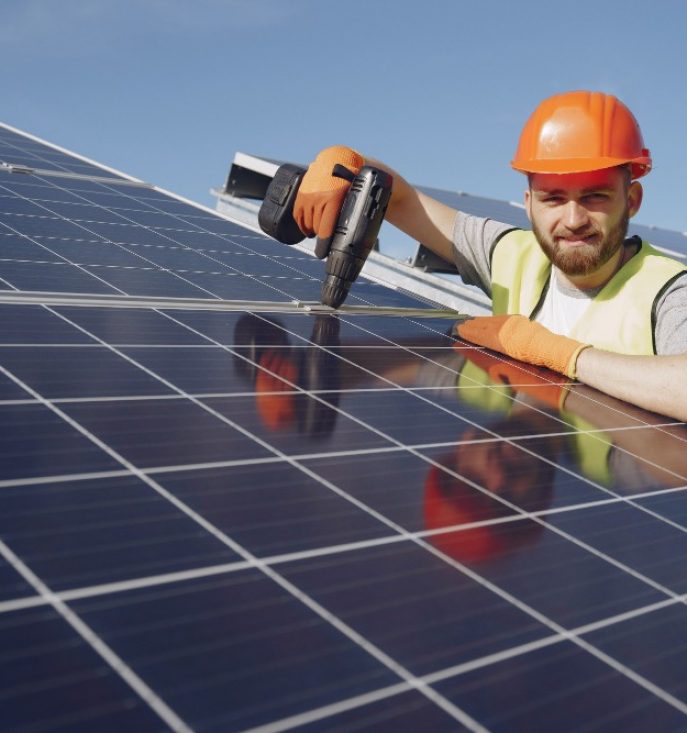 Photo d'un artisan qui installe des panneaux solaires