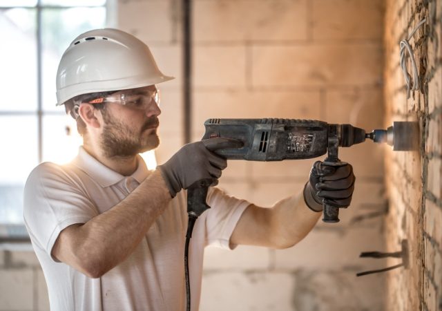Photo d'un artisan qui perce un mur