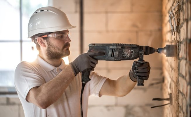 Photo d'un artisan qui perce un mur
