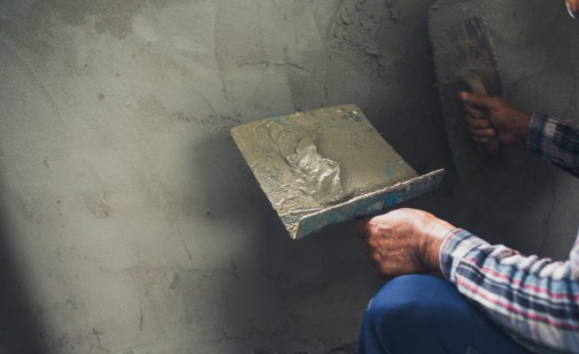 Plasterer renovating indoor walls.