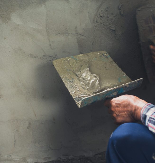 Plasterer renovating indoor walls.